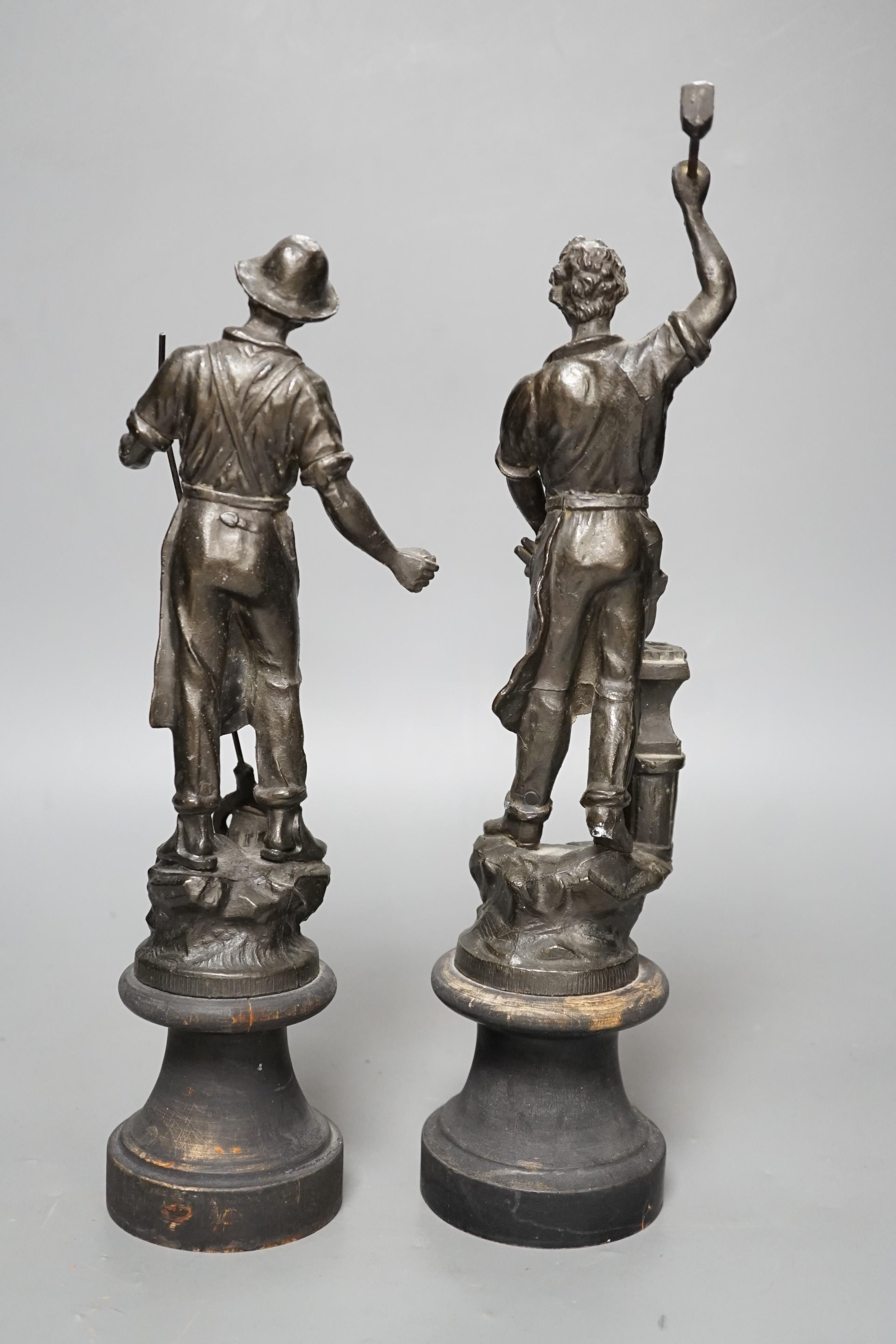 A pair of spelter blacksmith figures, tallest 34cms high